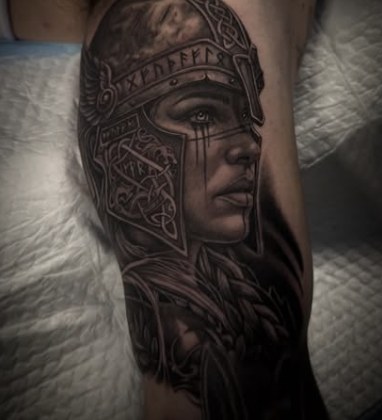Black and grey realism tattoo of a valkyrie warrior wearing a runic helmet