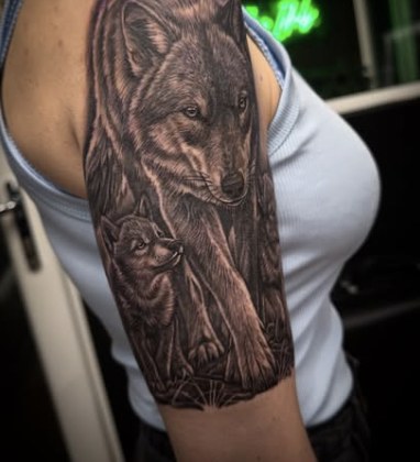 Black and grey realism tattoo of an adult wolf with a pup