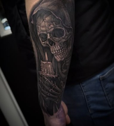 Black and grey realism tattoo of a hooded grim reaper skull holding a lit candle